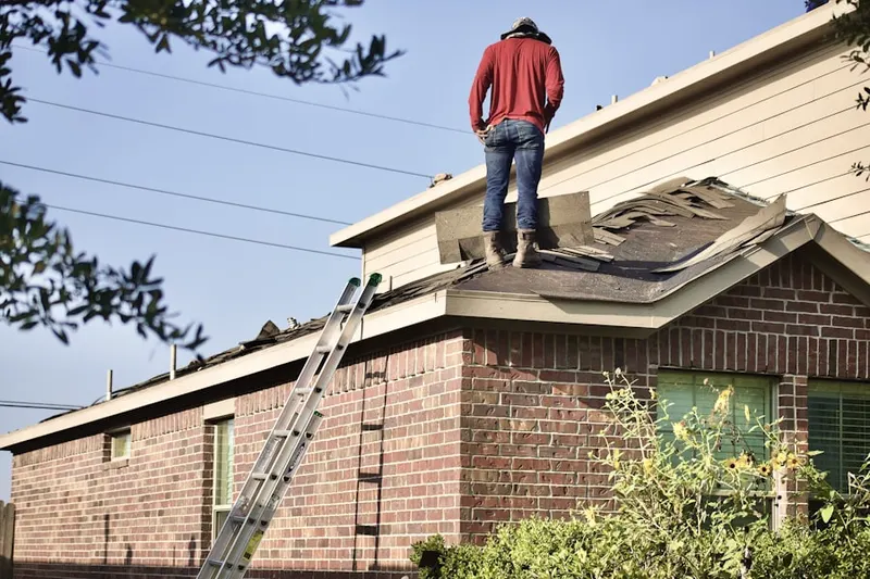 Professional roofer working on a residential roof in The Timbers